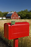 Rural mailbox with red barn in the background